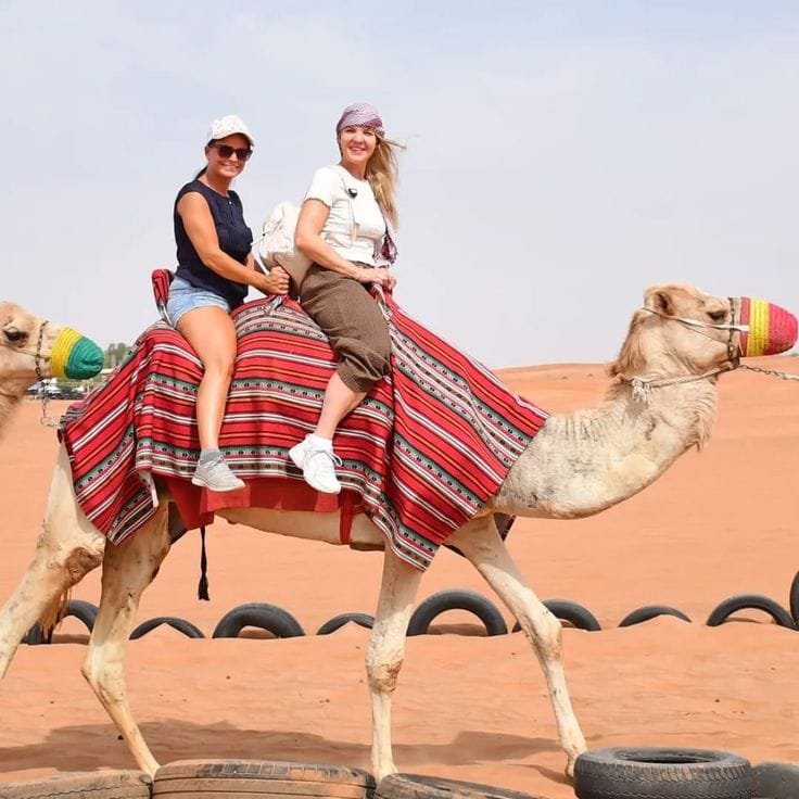 Group of tourists riding camels at a desert safari