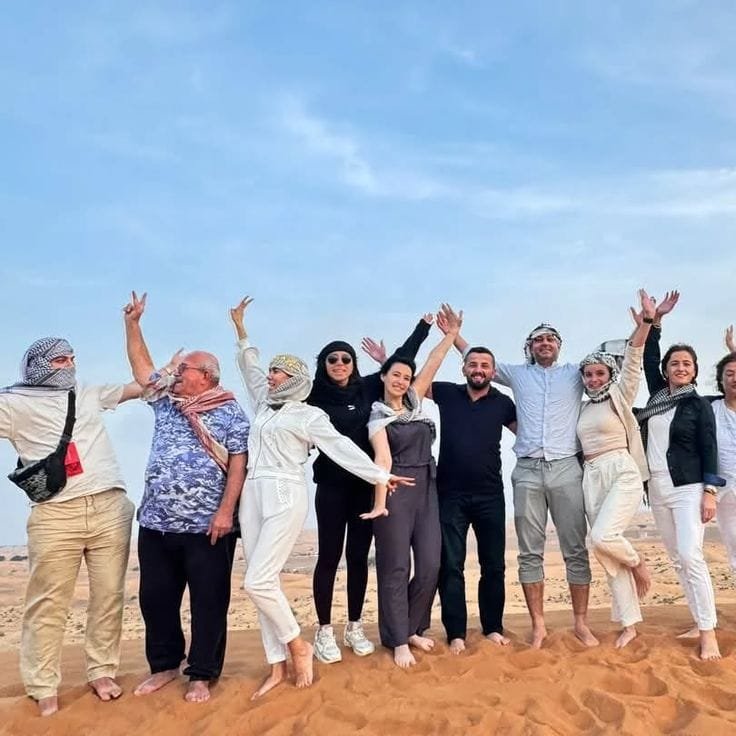 Group of tourists having fun on desert sand dunes