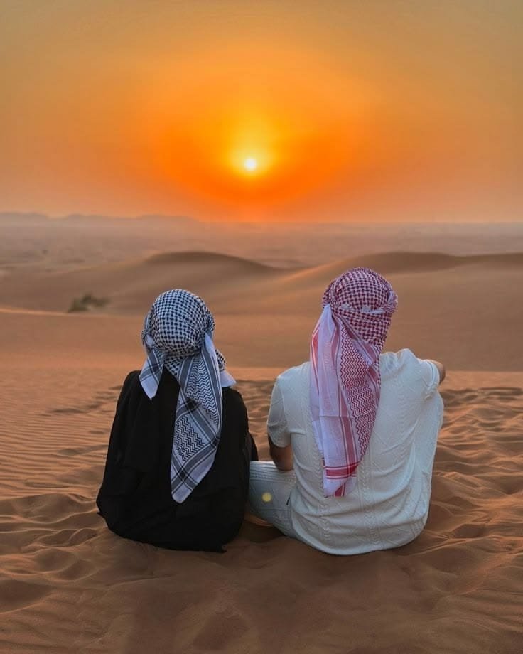 Couple photographed at golden hour on the Al Khatim dunes during an Abu Dhabi evening safari