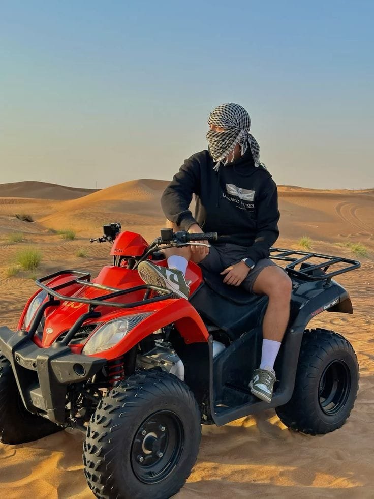 Guest posing on a quad bike before a desert run in Abu Dhabi