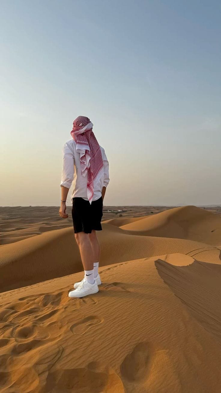A guest sitting quietly on the crest of a dune at Al Khatim, Abu Dhabi