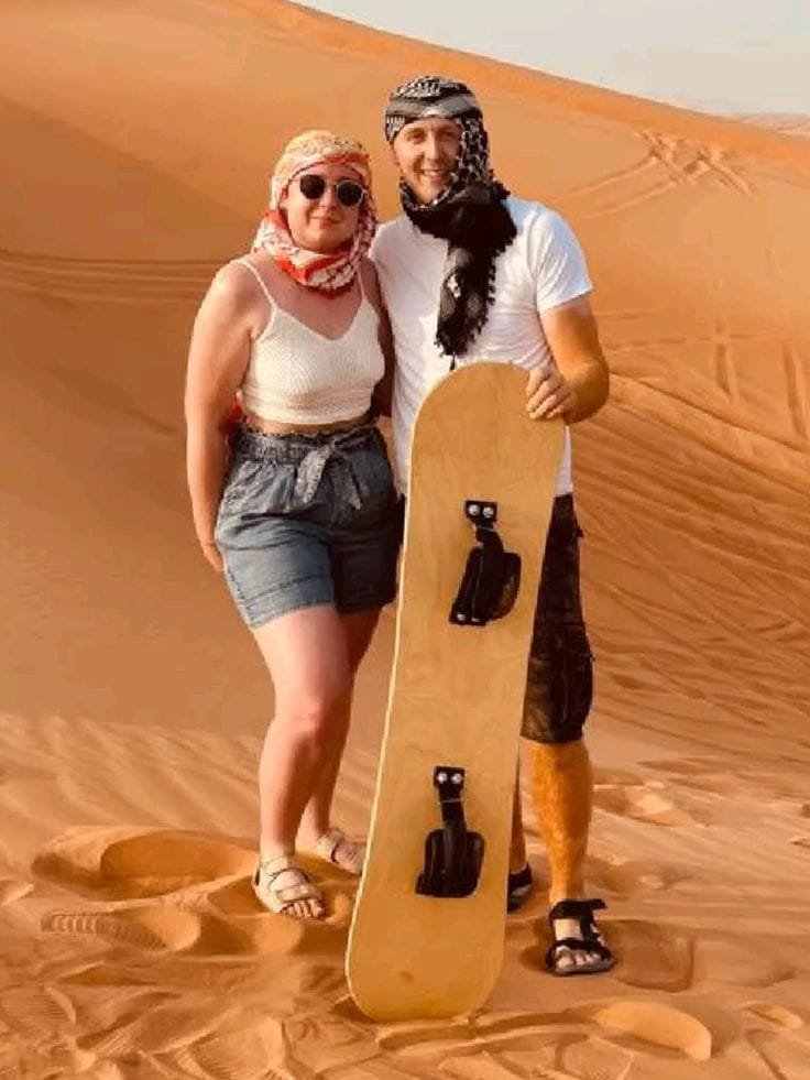 Sandboarding on the golden dunes at an Abu Dhabi evening safari