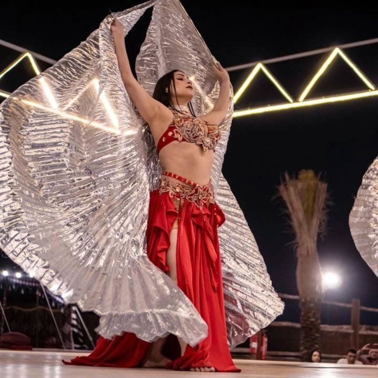 Belly dance performance under desert camp lights at a safari