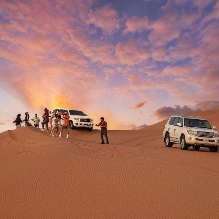 Tourists posing for photoshoot on golden desert sand