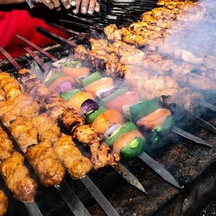 Live BBQ grill serving chicken tikka and lamb kebab at the Abu Dhabi desert safari camp