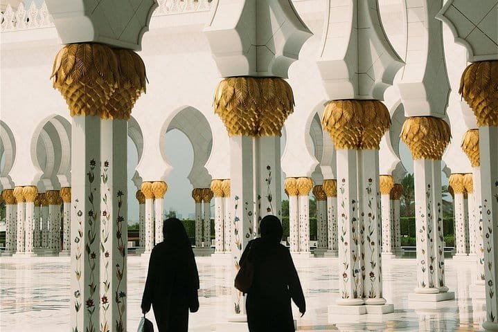 Inside Sheikh Zayed Grand Mosque Visitors walking beneath the gold-topped columns inside Sheikh Zayed Grand Mosque