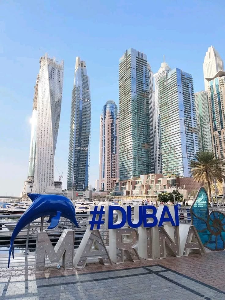 Dubai Marina skyline behind a hashtag DUBAI sign