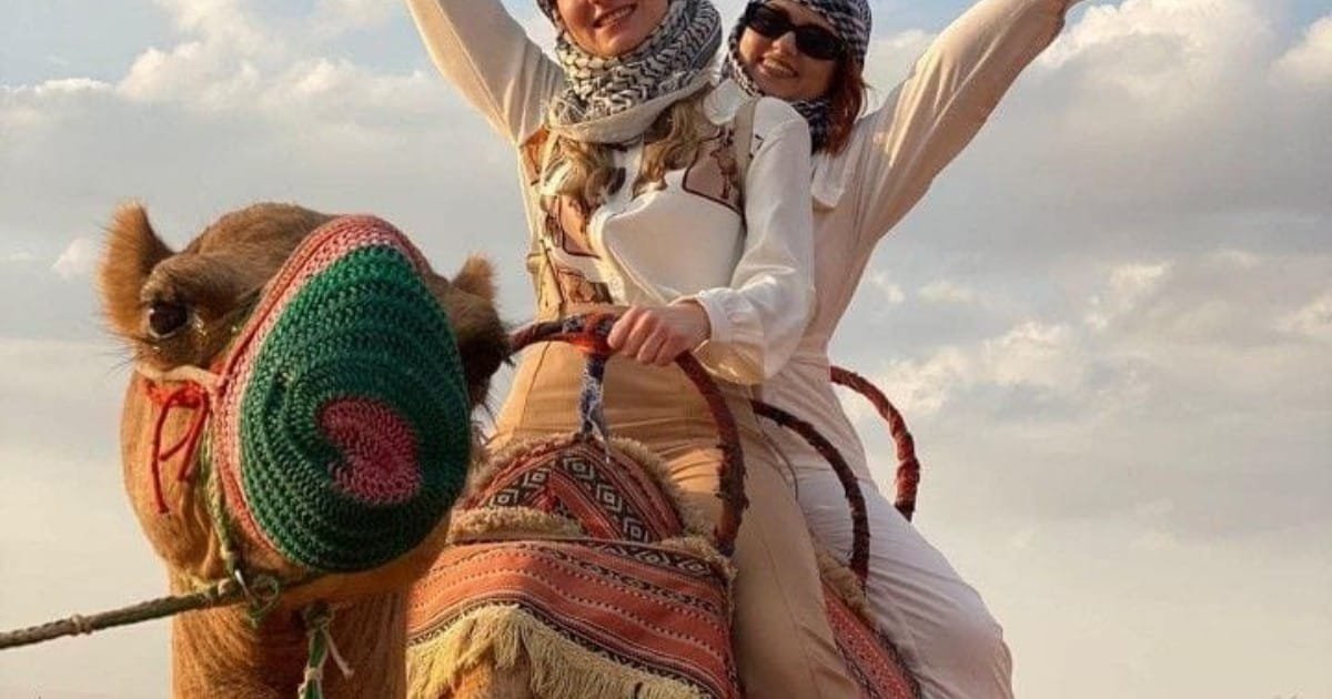 Guests riding a camel in the Dubai desert on a desert safari