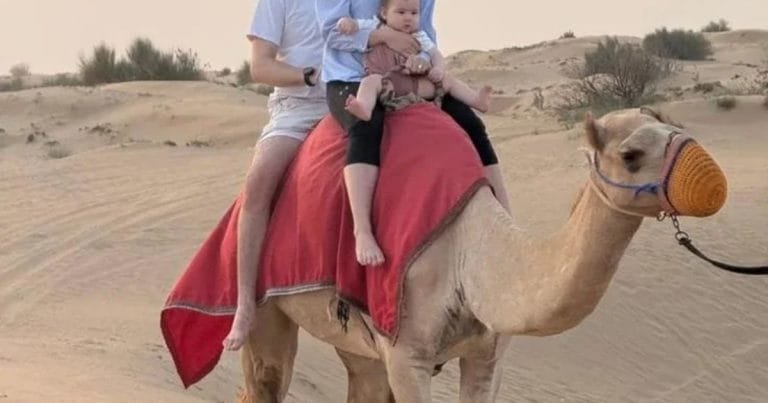 A family camel trek across the dunes near,
