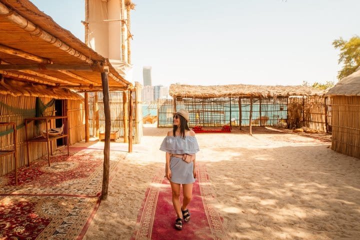 Heritage Village Palm Shelters A visitor walking through the palm-frond shelters at Abu Dhabi Heritage Village