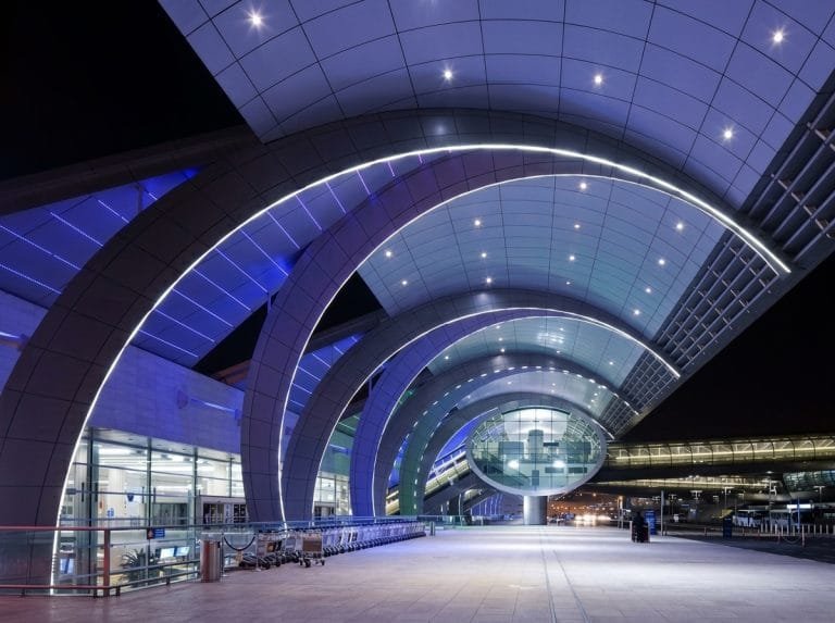 Curved illuminated architecture of the Dubai airport terminal at night