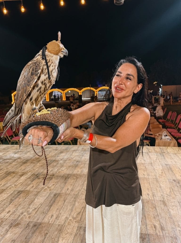 Guest holding a falcon on her arm at a desert camp