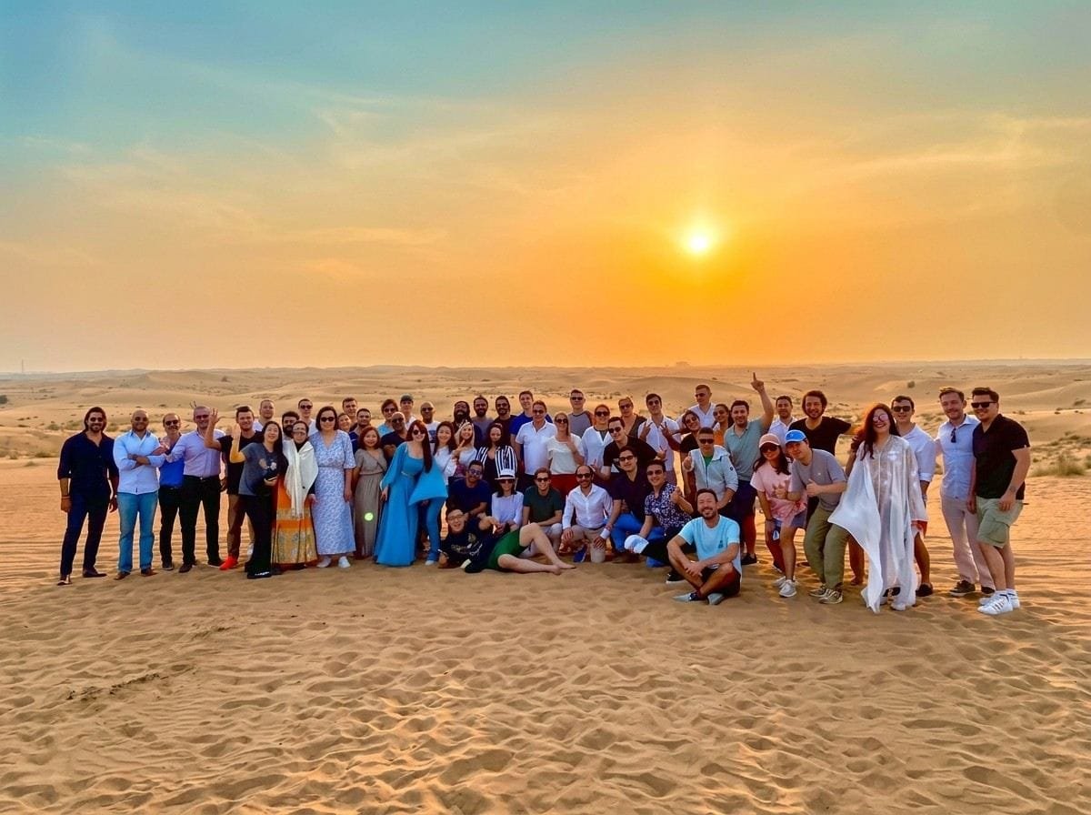Group of guests together on the dunes at sunset on a custom Abu Dhabi layover run