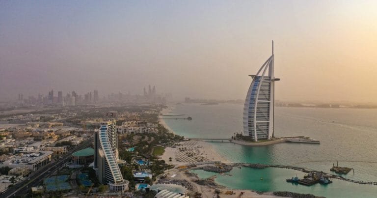 The Burj Al Arab and the Dubai skyline at sunset, seen across the water