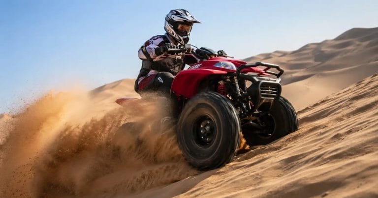 Quad bike rider on Dubai desert dunes — AED 200 single, 300 double